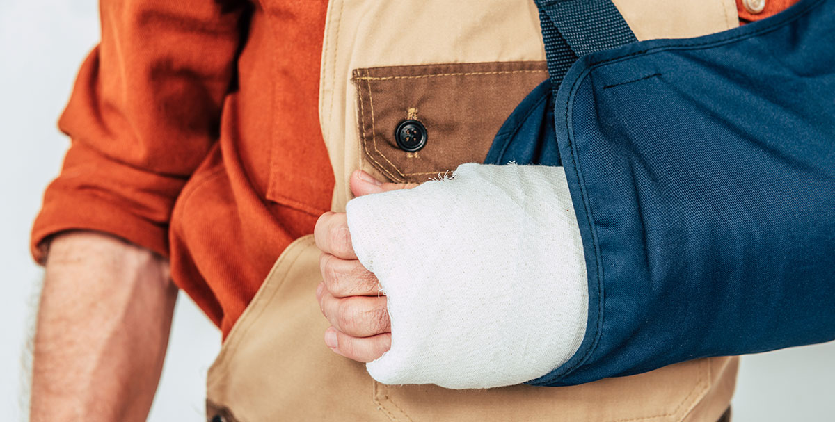A close up of a mans arm in a cast with a sling